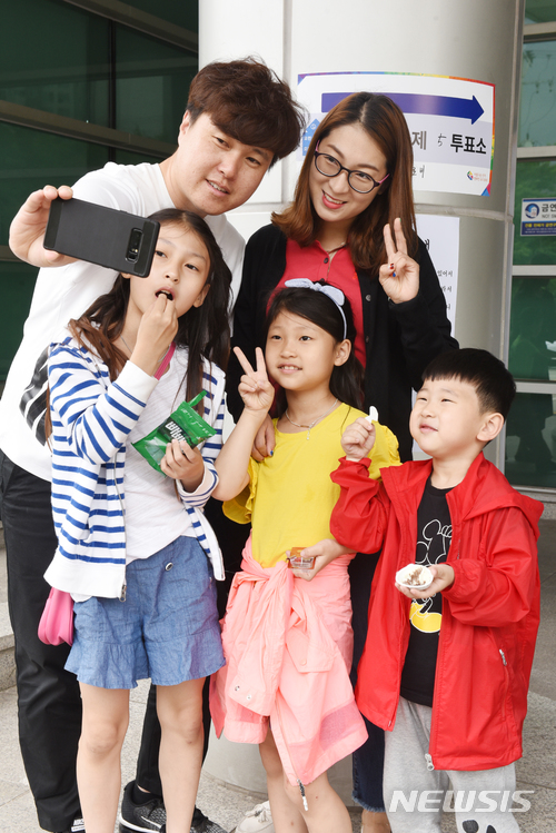 【울산=뉴시스】배병수 기자 = 제7회 전국동시지방선거 및 국회의원 제 보궐선거 일인 13일 오전 울산시 남구 삼산 제5투표소에서 유권자가 투표를 하고난 뒤 가족들과 함께 인증샷을 찍고 있다. 2018.06.13. bbs@newsis.com.