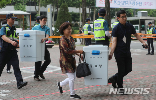 【서울=뉴시스】임태훈 기자 = 제7회 전국동시지방선거 및 국회의원 재·보궐선거가 끝난 13일 오후 서울 송파구 잠실실내체육관에 마련된 광진구선거관리위원회 개표소에서 관계자들이 봉인된 투표함을 옮기고 있다. 2018.06.13.&nbsp; taehoonlim@newsis.com