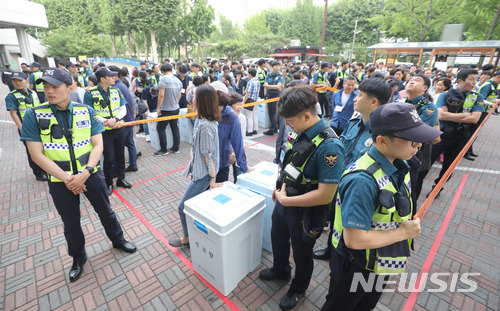 【서울=뉴시스】임태훈 기자 = 제7회 전국동시지방선거 및 국회의원 재·보궐선거가 끝난 13일 오후 서울 송파구 잠실실내체육관에 마련된 광진구선거관리위원회 개표소에서 경찰이 검수를 위해 대기하는 투표함을 지키고 있다. 2018.06.13.&nbsp; taehoonlim@newsis.com