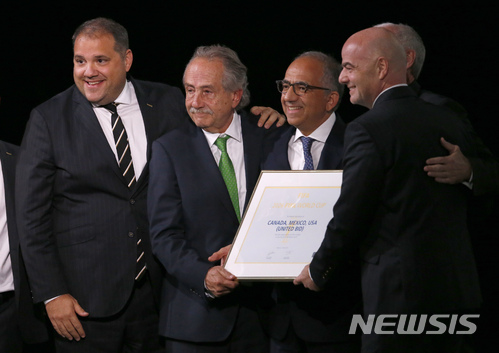 Delegates of Canada, Mexico and the United States celebrate with FIFA President Gianni Infantino, right, after winning a joint bid to host the 2026 World Cup at the FIFA congress in Moscow, Russia, Wednesday, June 13, 2018. From left: Victor Montagliani the president of CONCACAF, Decio de Maria, President of the Football Association of Mexico, Carlos Cordeiro, U.S. soccer president and Steve Reed, president of the Canadian Soccer Association (covered by Infantino). (AP Photo/Alexander Zemlianichenko)