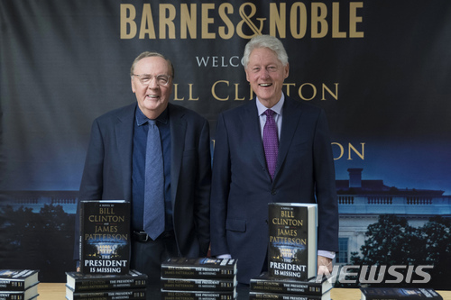 FILE - In this June 5, 2018 file photo, former President Bill Clinton, right, and author James Patterson pose for photographers during an event to promote their new novel, "The President is Missing," in New York. Clinton’s debut as a novelist is already one of the year’s biggest hits. “The President is Missing,” the thriller he co-wrote with James Patterson, sold 250,000 copies its first week. Alfred A. Knopf and Little, Brown and Co., the book’s co-publishers, announced Wednesday, June 13 that the number includes hardcover, e-book and audio sales. (AP Photo/Mary Altaffer, File)