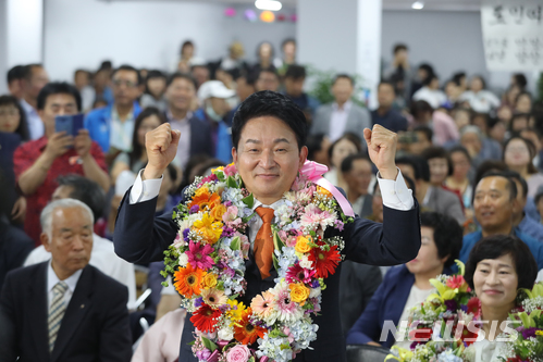 【제주=뉴시스】우장호 기자 = 무소속 원희룡 제주지사 후보가 13일 제주시 자신의 선거사무실에서 당선이 확실시되자 꽃다발을 목에 걸고 기념촬영을 하고 있다. 2018.06.13. woo1223@newsis.com