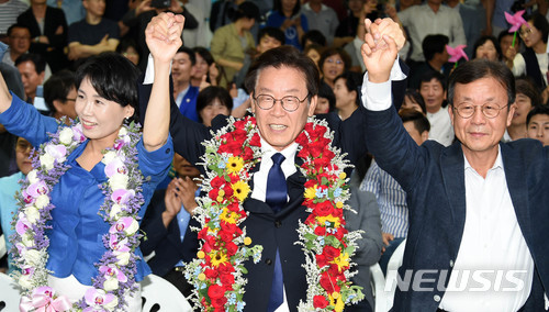 【수원=뉴시스】이정선 기자 = 당선이 확실시되는 이재명 더불어민주당 경기지사 후보가 13일 오후 경기 수원 팔달구 명캠프에서 부인 김혜경 씨와 함께 손을 맞잡고 기념촬영하고 있다. 2018.06.13. ppljs@newsis.com