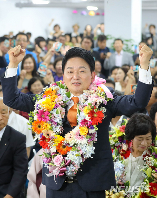 【제주=뉴시스】우장호 기자 = 무소속 원희룡 제주지사 후보가 13일 제주시 자신의 선거사무실에서 당선이 확실시되자 꽃다발을 목에 걸고 기념촬영을 하고 있다. 2018.06.13. woo1223@newsis.com