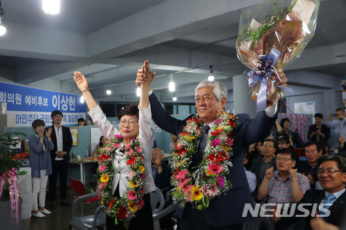 【울산=뉴시스】안정섭 기자 = 14일 더불어민주당 이상헌 울산 북구 국회의원 당선인이 북구 호계로에 위치한 자신의 선거사무소에서 부인 김춘선씨와 손을 맞잡고 환호하고 있다. 2018.06.14. (사진=더불어민주당 울산시당 제공)&nbsp; photo@newsis.com 