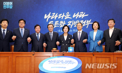 【서울=뉴시스】이종철 기자 = 6.13 지방선거에서 압승한 더불어민주당 추미애 대표, 홍영표 원내대표, 선대위원장들이 14일 오전 서울 여의도 국회에서 열린 중앙선거대책위원회의에서 서로 손을 잡고 국민들의 지지에 감사하고 있다. 2018.06.14. jc4321@newsis.com