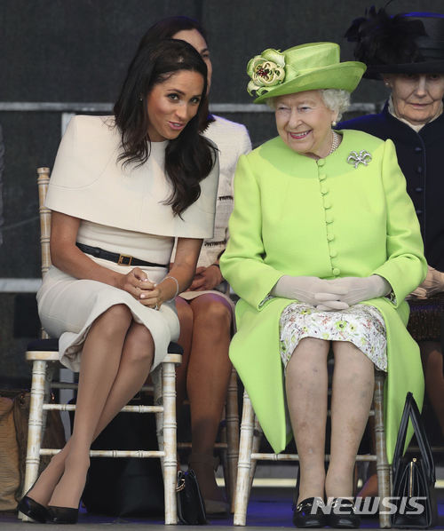 【윈즈=AP/뉴시스】 영국의 엘리자베스 2세 여왕과 손자 해리 왕자의 신부인 메건(서식스 공작부인)이 14일 잉글랜드 북서부 도시에서 교량 기공식에 참석해 사이좋게 이야기를 나누고 있다. 여왕과 손부 메건의 첫 공동 외부행사이다. 2018. 6. 14.&nbsp; 