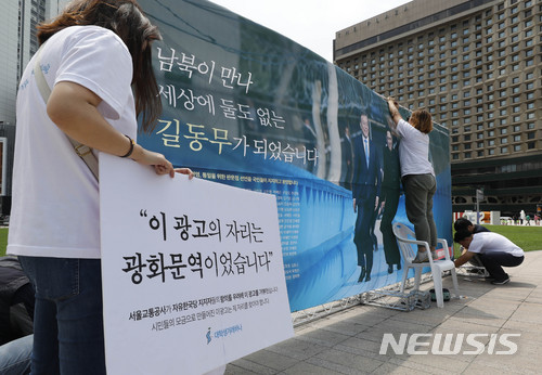 【서울=뉴시스】최동준 기자 = 대학생 겨레하나 회원들이 15일 서울 중구 서울광장에 '도보다리 산책 판문점 선언 지지 시민광고'를 설치하고 있다. 이들은 시민 200여명의 참여로 지하철역 광고 게재를 준비했는데 서울교통공사가 승인하지 않았다고 밝혔다. 2018.06.15. photocdj@newsis.com