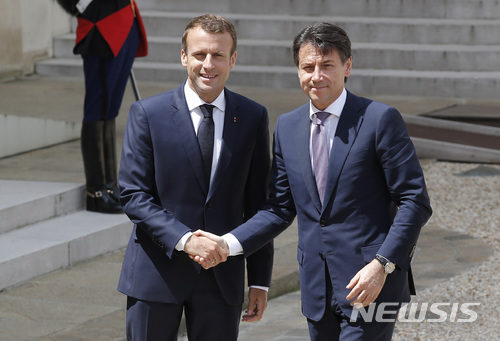 【파리=AP/뉴시스】 프랑스의 에마뉘엘 마크롱 대통령(왼쪽)이 15일 엘리제궁에서 이탈리아의 주세페 콘테 총리를 환영하며 악수하고 있다. 보름 전 들어선 이탈리의 포퓰리즘 정부는 지난 일요일 독불 자선 단체 구조선이 지중해상에서 600여 명의 이주민을 태우고 입항하려하자 이를 거부했다. 이에 마크롱 대통령이 강하게 비난해 양국 관계가 한때 날카롭게 대립했다. 콘테 총리가 해소 차원에서 방문했다. 2018. 6. 15. 