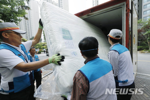 【서울=뉴시스】최동준 기자 = 유영민 과학기술통신부 장관, 강성주 우정사업본부장과 우체국 직원들이 16일 서울 송파구 잠실의 한 아파트 단지에서 대진침대 매트리스를 우체국 택배 차량에 수거하고 있다. 2018.06.16. photocdj@newsis.com