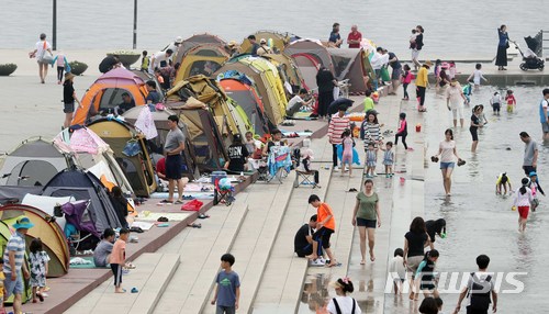 【서울=뉴시스】고승민 기자 = 전국 낮 최고기온이 32도까지 오르는 등 후덥지근한 날씨를 보인 17일 오후 서울 여의도 물빛광장을 찾은 시민과 어린이들이 물장난하며 즐거운 시간을 보내고 있다. 2018.06.17. kkssmm99@newsis.com