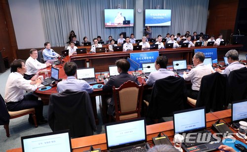 【서울=뉴시스】 이달부터 300인 이상 사업장의 근로시간 주52시간 근무제가 본격 시행되면서 청와대 근무 풍경에도 변화가 생기고 있다. 공무원은 직접 적용 대상이 아니지만 근로시간 단축 문화에 동참한다는 취지다. 하지만 국정 현안이 많아 정시퇴근과 연차사용이 어렵다는 분위기도 많다. 사진은 지난달 18일 문재인 대통령이 청와대 여민관에서 수석보좌관회의를 주재하는 모습이다. 회의는 청와대 전직원에게 생중계된다. (사진=뉴시스 자료사진) 2018.07.01.&nbsp; photo1006@newsis.com