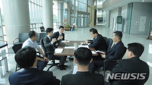 【서울=뉴시스】 남북 공동연락사무소 준비인력과 북측 인사가 19일 개성공단 내 종합지원센터 로비에서 협의를 하고 있다. (사진=통일부 제공) 