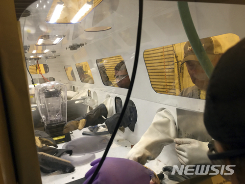 【로스앨러모스( 미 뉴멕시코주) = AP/뉴시스】로스앨러모스 국립 원자력 연구소의 실험실에서 실물크기의 고무장갑을 사용해서 핵물질을 다루는 실험을 하고 있다.&nbsp; 한 때 원자폭탄을 제조했던 이 국립 핵연구소에서는 올해 5월에도 방사능 안전관리국의 검사 결과 작업자들의 손을 비롯한 여러 곳에서 누출된 방사성 물질이 검출되어&nbsp; 방폐물 처리에 관한 비난과 소동이 잇따랐다.&nbsp;&nbsp;&nbsp; 