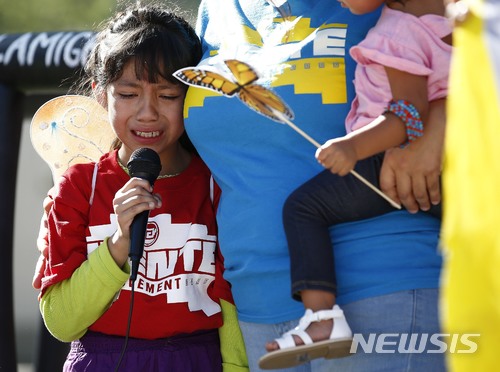 【피닉스(미 애리조나주)=AP/뉴시스】아버지와 강제로 헤어졌던 경험이 있는 아케미 바르가스라는 8살 소녀가 18일 미 애리조나주 주도 피닉스의 연방법원 앞에서 열린 불법 입국자 자녀 강제 격리에 반대하는 시위 도중 자신의 강제 격리 경험을 이야기하며 눈물을 흘리고 있다. 2018.6.19 