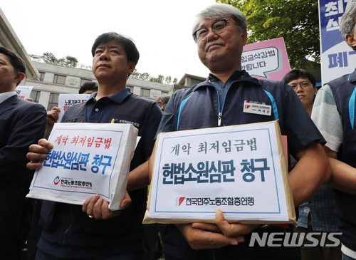【서울=뉴시스】이영환 기자 = 19일 오후 서울 종로구 헌법재판소 앞에서 열린 '양대노총-최저임금위원회 노동자 위원 공동 기자회견'에서 문현군(왼쪽) 한국노총 부위원장과 백석근 민주노총 사무총장이 개악 최저임금법 헌법소원심판 청구서를 들고 있다. 2018.06.19. 20hwan@newsis.com