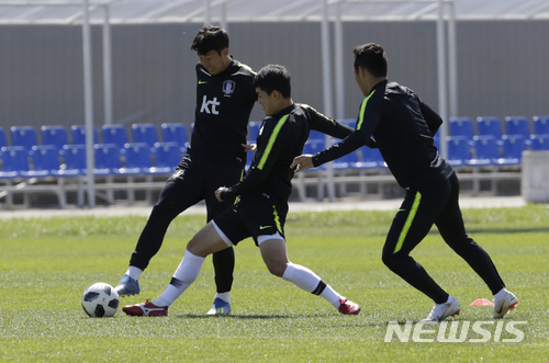 South Korea's Son Heung-min, left, goes for the ball with Ju Se-jong, center, and Moon Seon-min, right, during a training session of South Korea at the 2018 soccer World Cup at the Spartak Stadium in Lomonosov near St. Petersburg, Russia, Wednesday, June 20, 2018. (AP Photo/Lee Jin-man)
