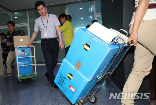 【세종=뉴시스】강종민 기자 = 공정거래위원회 퇴직자들의 취업 특혜 혐의를 포착한 검찰이 공정위 기업집단국 등에 대해 압수수색을 벌인 20일 오후 압수품을 가지고 차량으로 향하고 있다. 2018.06.20. ppkjm@newsis.com