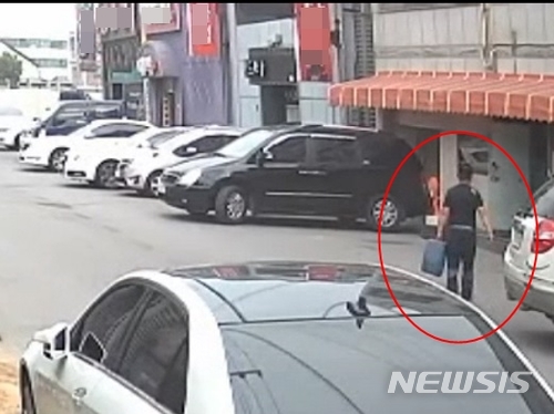 【전주=뉴시스】강인 기자 = 지난 17일 33명의 사상자를 낸 전북 군산 유흥주점 화재 방화범인 이모(55)씨가 범행 전 휘발유가 든 기름통을 들고 해당 주점 인근 사무실로 가는 모습이다. 2018.06.21 (사진=전북경찰청 제공) kir1231@newsis.com 