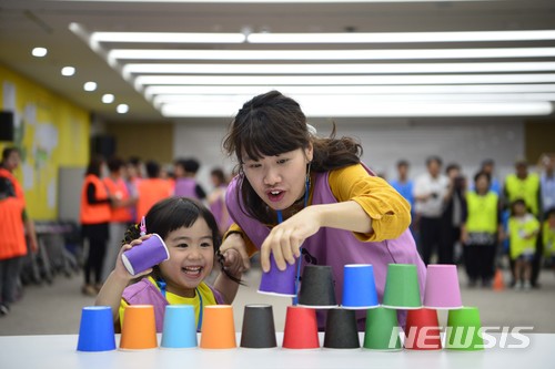 【서울=뉴시스】 21일 경북 경주에서 열린 '다문화과정 농촌정착지원과정 5기'현장교육에서 다문화가족 아이가 컵쌓기 가족게임을 하고 있다. 2018.06.21. (사진=농협 제공) photo@newsis.com