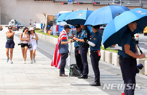 【서울=뉴시스】배훈식 기자 = 대구를 비롯한 영남지방과 강원에 폭염주의보가 발효된 22일 오후 서울 종로구 광화문 광장에 배치된 의무경찰들이 햇빛가리개 용 우산을 쓰고 있다. 2018.06.22. dahora83@newsis.com