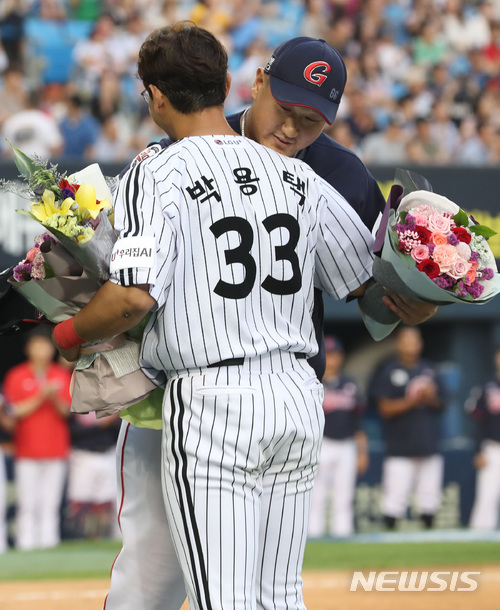 【서울=뉴시스】이영환 기자 = 23일 서울 송파구 잠실야구장에서 열린 2018 신한은행 마이카 KBO리그&nbsp; LG 트윈스와 롯데자이언츠의 경기, LG 박용택이 4회말 1사 2루에서 2타점 2루타를 날리며 개인통산 2319안타를 기록하자 롯데 이대호가 축하 꽃다발을 전하고 있다.이날 경기 전까지 통산 2317안타를 기록 중이던 박용택은 1회말 2루타를 날려 양준혁이 보유한 KBO 리그 최다안타(2318안타)와 타이를 이루고 4회말 2루타로 기록을 넘어 섰다. 2018.06.23. (사진=LG트윈스 제공)&nbsp; photo@newsis.com