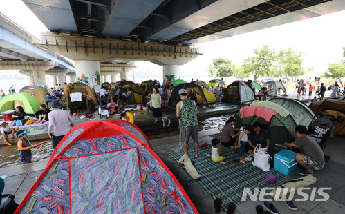 【서울=뉴시스】이영환 기자 = 연일 불볕더위가 이어지며 서울에 올해 첫 폭염주의보가 내린 24일 오후 서울 영등포구 여의도 마포대교 밑에서 시민들이 텐트를 치고 휴식을 취하고 있다. 2018.06.24. 20hwan@newsis.com