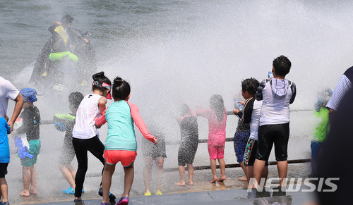【서울=뉴시스】이영환 기자 = 연일 불볕더위가 이어지며 서울에 올해 첫 폭염주의보가 내린 24일 오후 서울 영등포구 여의도 한강공원 물빛광장에서 어린이들이 제트스키가 만든 인공 파도를 즐기고 있다. 2018.06.24.&nbsp; 20hwan@newsis.com