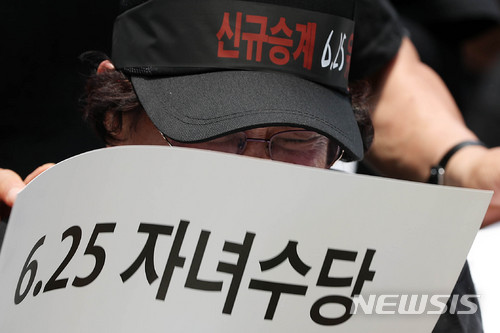 【서울=뉴시스】 홍효식 기자 = 대한민국 6·25 전몰군경 미수당 유자녀회원들이 25일 오후 서울 종로구 보신각 앞에서 열린 유자녀 수당 차별 규탄 대회에서 눈물을 흘리고 있다. 2018.06.25. yesphoto@newsis.com