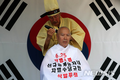 【서울=뉴시스】 홍효식 기자 = 대한민국 6·25 전몰군경 미수당 유자녀 비대위 김화룡 위원장이 25일 오후 서울 종로구 보신각 앞에서 열린 유자녀 수당 차별 규탄 대회에서 삭발식을 하고 있다. 2018.06.25. yesphoto@newsis.com