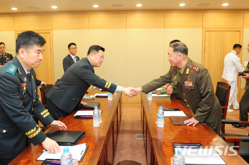 【서울=뉴시스】조용근(왼쪽) 육군 대령이 25일 오전 경기 파주시 우리측 남북출입사무소에서 열린 동서해지구 軍통신선 복구를 위한 남북 통신실무접촉에 나선 북한 엄창남 육군대좌와 악수하고 있다. 2018.06.25.(사진=국방부 제공) photo@newsis.com