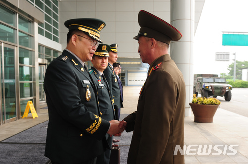 【서울=뉴시스】조용근(왼쪽) 육군 대령이 25일 오전 경기 파주시 우리측 남북출입사무소에서 열린 동서해지구 軍통신선 복구를 위한 남북 통신실무접촉에 나선 북한 엄창남 육군대좌와 악수하고 있다. 2018.06.25.(사진=국방부 제공) photo@newsis.com