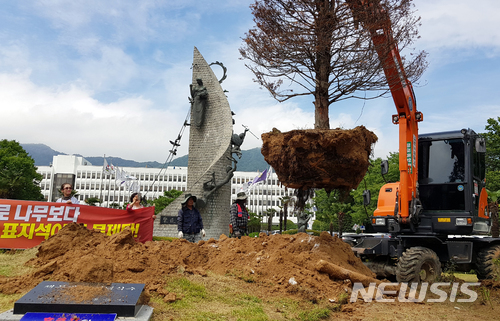 【창원=뉴시스】 홍정명 기자 = 27일 오후 홍준표 전 경남지사가 지난 2016년 6월 1일 도청 정문 가운데 심은 '채무제로 기념 나무‘가 철거되고 있다. 이 나무는 40년생 주목으로 경남도의 관리에도 불구하고 갈수록 시들어 말라죽은 것과 다름이 없어 철거됐다. 기념수 앞에는 ‘채무제로기념식수’ 표지석이 있으나 이날 철거하지는 않았다.2018.06.27. hjm@newsis.com