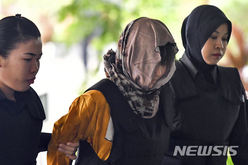 【샤알람(말레이시아)=AP/뉴시스】북한 김정은 국무위원장의 이복형 김정남을 암살한 여성 용의자들에 대한 공판이 말레이시아 샤알람 고등법원에서 27일 개시됐다. 용의자 중 하나인 베트남 국적의 도안 티 흐엉(29)이 여경들과 함께 법정에 들어서고 있다. 2018.06.27