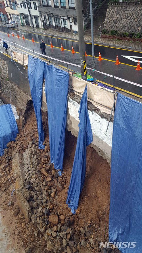 【부산=뉴시스】 하경민 기자 = 부산지역에 호우경보가 내려진 28일 부산 영도구 흰여울마을의 한 옹벽(가로 20m, 세로 10m)이 무너져 있다. 2018.06.28. (사진=부산경찰청 제공)yulnetphoto@newsis.com