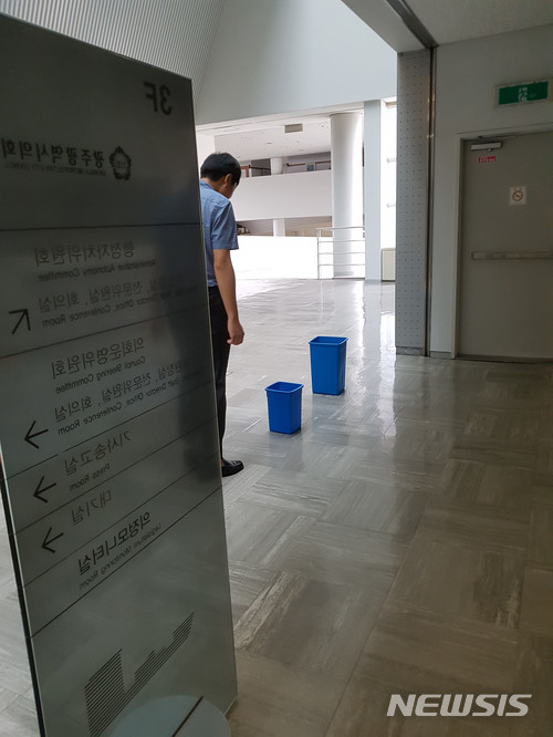 【광주=뉴시스】송창헌 기자 = 호우주의보가 내려진 28일 광주시청사 일부에서 누수가 발생한 가운데 한 직원이 물받이 양동이를 살펴보고 있다. 2018.06.28 goodchang@newsis.com