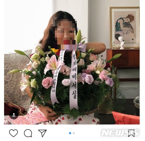 【서울=뉴시스】 한 뷰티 크리에이터가 청와대로부터 신제품 축하 화환을 받았다고 올린 사진. 화환 리본에 '청와대 비서실'이라고 적혀 있다. 해당 글은 인터넷상에서 진위 논란으로 이어졌다. 현재 이 사진은 삭제됐다. (사진=인스타그램 캡쳐) 2018.06.28. photo@newsis.com