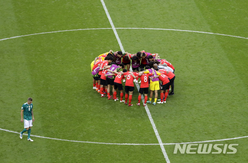 Germany's Toni Kroos leaves the field as South Korea players gather together at the end of the group F match between South Korea and Germany, at the 2018 soccer World Cup in the Kazan Arena in Kazan, Russia, Wednesday, June 27, 2018. (AP Photo/Sergei Grits)