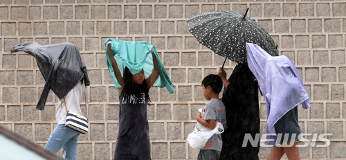 【서울=뉴시스】이영환 기자 = 대기불안정으로 갑작스레 소나기가 내린 28일 오후 서울 종로구 광화문 앞에서 시민들이 옷으로 비를 가리며 이동하고 있다. 2018.06.28.&nbsp; 20hwan@newsis.com