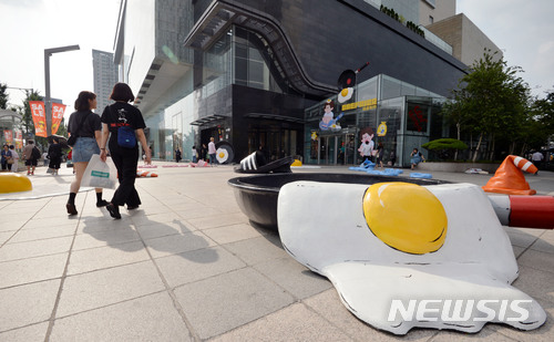 【대구=뉴시스】우종록 기자 = 29일 오후 대구시 중구 계산동 현대백화점 대구점 앞 광장에 녹아버린 러버콘, 달걀 프라이, 녹아 붙은 슬리퍼 등 이색 조형물이 설치돼 시민들의 눈길을 끌고 있다. 2018.06.29. wjr@newsis.com