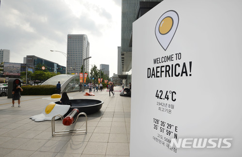 【대구=뉴시스】우종록 기자 = 29일 오후 대구시 중구 계산동 현대백화점 대구점 앞 광장에 녹아버린 러버콘, 달걀 프라이, 녹아 붙은 슬리퍼 등 이색 조형물이 설치돼 시민들의 눈길을 끌고 있다. 2018.06.29. wjr@newsis.com