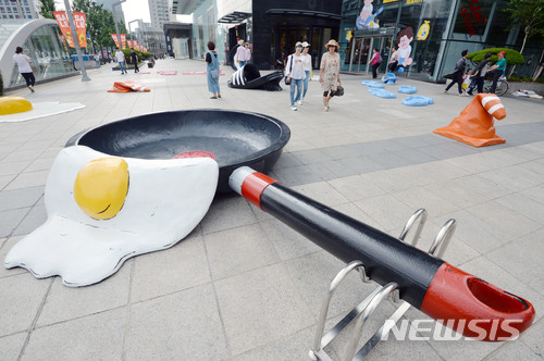 【대구=뉴시스】우종록 기자 = 29일 오후 대구시 중구 계산동 현대백화점 대구점 앞 광장에 녹아버린 러버콘, 달걀 프라이, 녹아 붙은 슬리퍼 등 이색 조형물이 설치돼 시민들의 눈길을 끌고 있다. 2018.06.29.&nbsp; wjr@newsis.com 