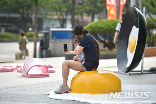 【대구=뉴시스】우종록 기자 = 29일 오후 대구시 중구 계산동 현대백화점 대구점 앞 광장에 녹아버린 러버콘, 달걀 프라이, 녹아 붙은 슬리퍼 등 이색 조형물이 설치돼 시민들의 눈길을 끌고 있다. 2018.06.29. wjr@newsis.com