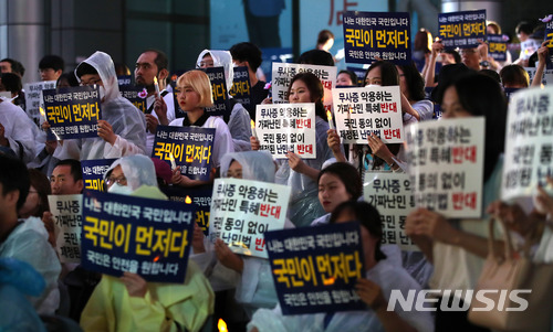 【서울=뉴시스】김선웅 기자 = 제주도 예멘 난민 수용에 반대하는 시민들이 30일 오후 서울 종로구 세종로사거리에서 집회를 열고 난민법 및 무사증 폐지를 촉구하고 있다. 2018.06.30. mangusta@newsis.com