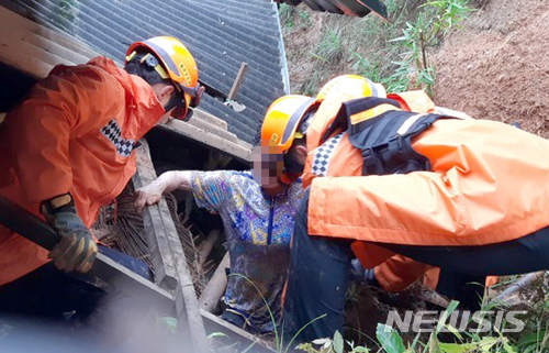 【보성=뉴시스】류형근 기자 = 광주와 전남지역에 많은 비가 내리고 있는 가운데 소방대원들이 1일 오전 8시2분께 전남 보성군 보성읍 한 마을 주택 뒷편에서 무너진 토사에 깔린 주민을 구조하고 있다. 보성지역에는 전날부터 이날 오후 1시현재 276.5㎜의 비가 내렸다. 2018.07.01. (사진=전남 보성소방서 제공) photo@newsis.com276.5