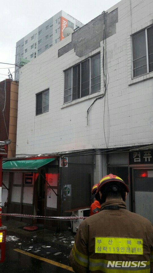  【부산=뉴시스】 제갈수만 기자 = 제7호 태풍 '쁘라삐룬'(PRAPIROON)이 북상 중인 3일 오후 부산지역은 점차 태풍의 영향권에 접어들면서 비바람이 거세지고 있는 가운데 크고 작은 피해가 발생하고 있다. 사진은 이날 오후 사상구 쾌법동 인근 건물에서 외벽 타일이 떨어져 소방관들이 안전 후속조치를 취하고 있다. 2018.07.03. (사진= 부산소방본부 제공)&nbsp; photo@newsis.com 