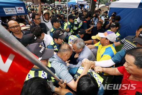 【서울=뉴시스】조성봉 기자 = 3일 오전 서울 중구 대한문 앞에서 '정리해고, 국가폭력, 사법살인 희생자 쌍용자동차 고 김주중 조합원 분향소 설치 기자회견'을 마친 금속노조 노동자들과 분향소 설치를 반대하는 태극기혁명국민운동본부 등 보수단체회원들이 격렬하게 몸싸움을 하고 있다. 2018.07.03.suncho21@newsis.com