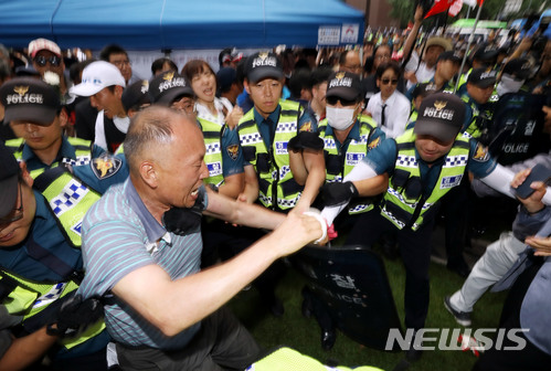 【서울=뉴시스】조성봉 기자 = 3일 오전 서울 중구 대한문 앞에서 열린 '정리해고, 국가폭력, 사법살인 희생자 쌍용자동차 고 김주중 조합원 분향소 설치 기자회견'에서 태극기혁명국민운동본부 등 보수단체회원들이 분향소 설치를 막기 위해 폭력을 행사하자 경찰이 이를 제지하고 있다. 2018.07.03.suncho21@newsis.com