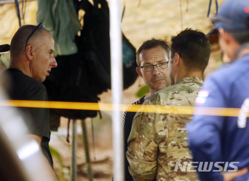 【매사이=AP/뉴시스】 영국 다이버 리처드 스탠턴(왼쪽)과 존 볼랜던(가운데)이 3일 태국 치앙라이주 매사이에 있는 동굴 실종자 수색 현장에서 미군 소속 수색구조팀 대원과 대화하고 있다. 스탠턴과 볼랜던은 앞서 지난 2일 동굴 안에서 실종자 13명을 찾아내는데 성공했다.2018.07.04 