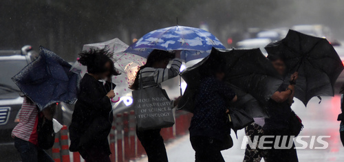 【부산=뉴시스】 하경민 기자 = 부산지역이 제7호 태풍 '쁘라삐룬'의 영향권에 접어든 3일 오후 부산 해운대구의 한 길거리에서 퇴근길에 오른 시민들이 거센 비바람에 맞서 힙겹게 우산을 쓴 채 걸어가고 있다. 2018.07.03.&nbsp; yulnetphoto@newsis.com